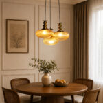 Ribbed Amber Kachori Glass 3-light adjustable pendant ceiling light with three rounded textured amber ribbed glass shades, elegant golden metal holders, 9-inch ceiling canopy, and 23-inch adjustable hanging cords.