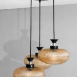 Amber Ribbed Glass cluster hanging light with four textured glass pendant shades, black metal fittings, and layered design for modern interior lighting.