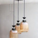 Decorative 3-Light cluster hanging light with three amber ribbed glass shades and black adjustable ceiling mount.