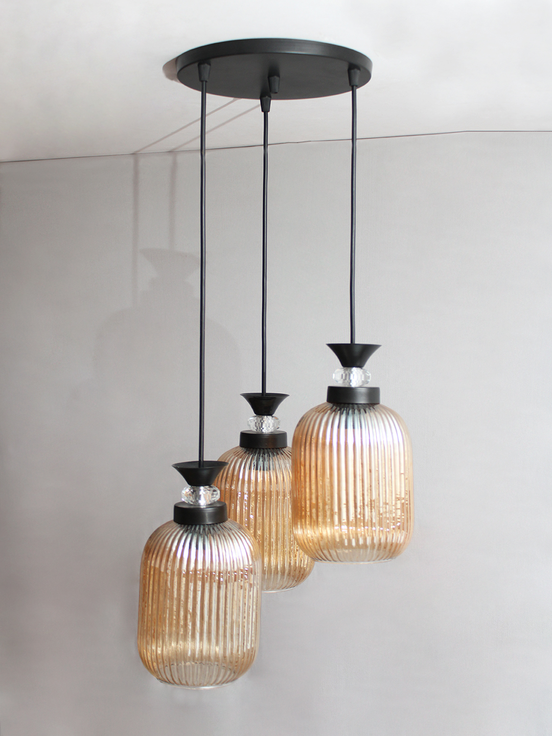 Decorative 3-Light Cluster Hanging Light Decorative 3-Light cluster hanging light with three amber ribbed glass shades and black adjustable ceiling mount.