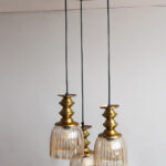 Ribbed Glass 3-Light adjustable pendant ceiling light with three textured glass shades, golden metal accents, black adjustable cords, 9-inch canopy, and elegant modern hanging design.