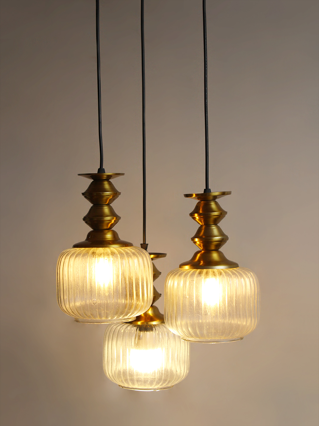 3-Light Ribbed Clear Glass Cluster Hanging Light 3-Light Ribbed Clear Glass adjustable pendant ceiling light with three 6-inch textured clear ribbed glass shades, decorative golden metal holders, black adjustable hanging cords, 9-inch circular canopy, and up to 23-inch adjustable height.