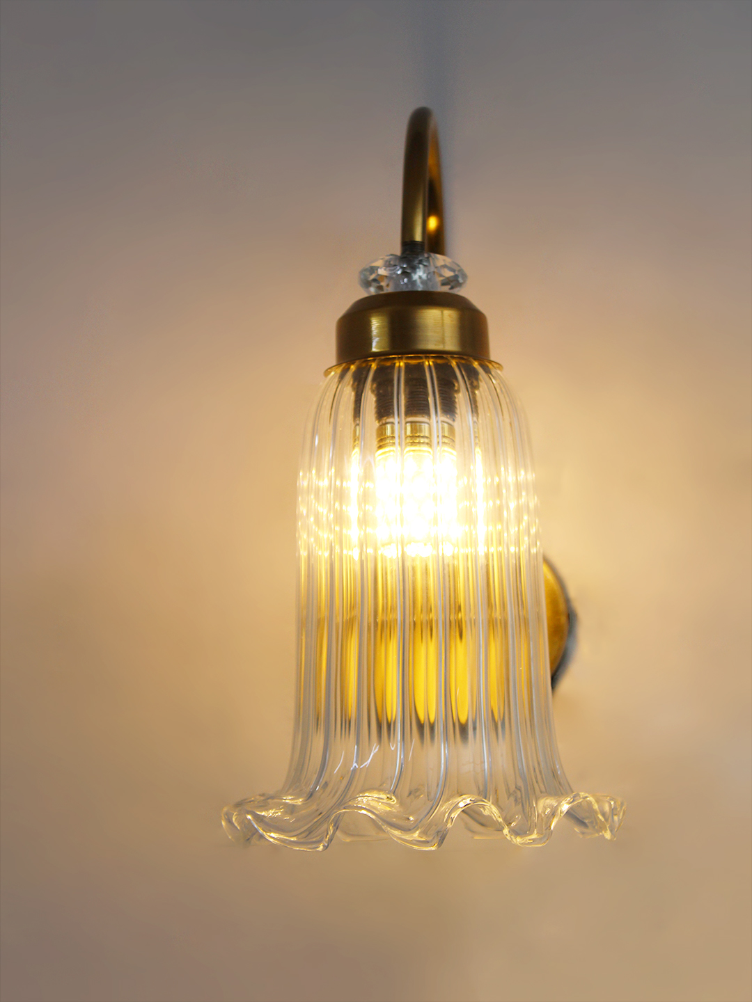 Antique Brass Fluted Glass Wall Sconce Antique brass fluted glass wall light with curved arm and decorative textured glass shade