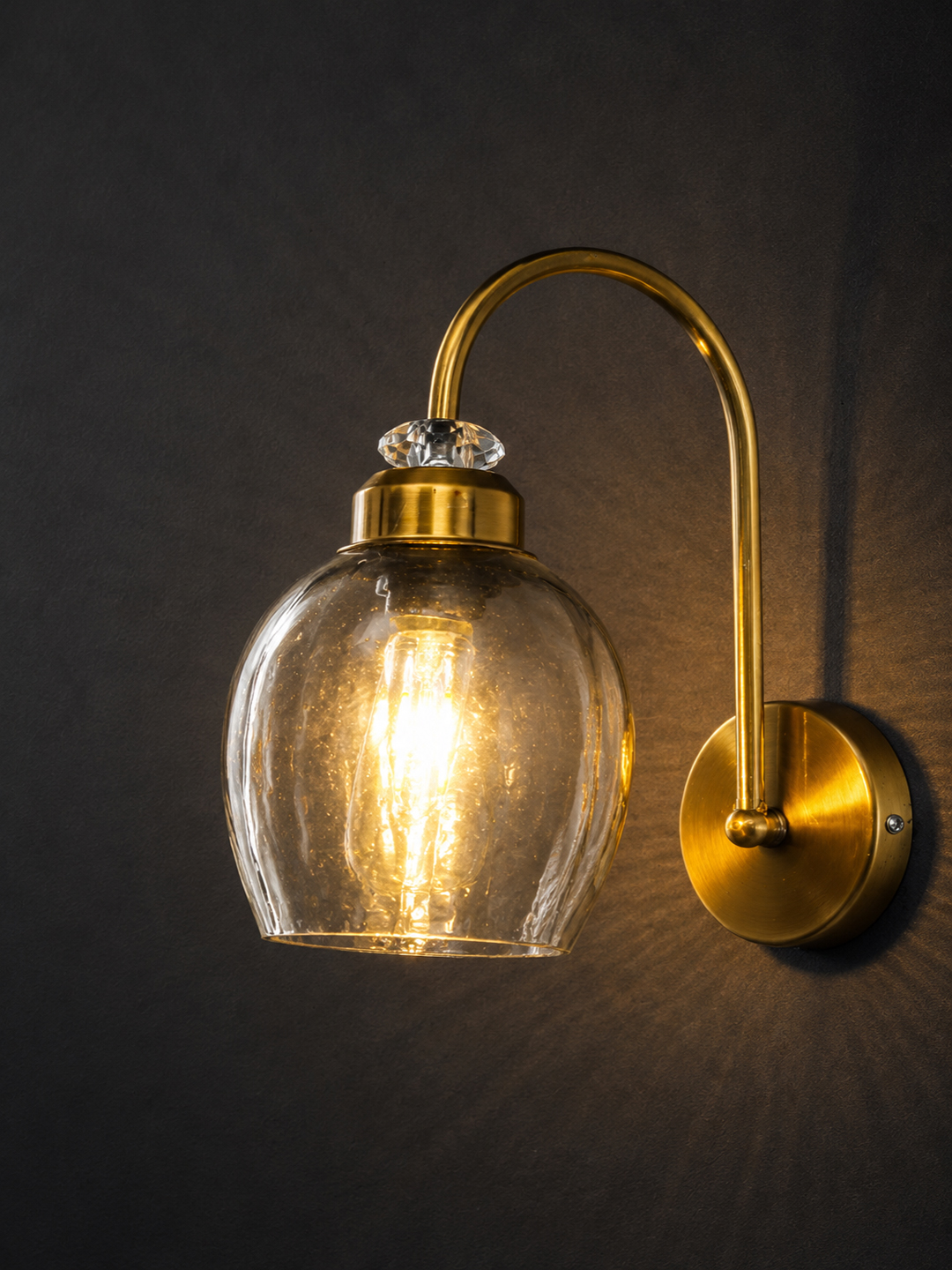 Antique Brass Smoked Glass Wall Sconce Antique brass smoked glass wall light with curved arm and round wall mount