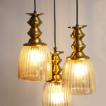 Ribbed Glass 3-Light adjustable pendant ceiling light with three textured glass shades, golden metal accents, black adjustable cords, 9-inch canopy, and elegant modern hanging design.