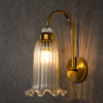 Antique brass fluted glass wall light with curved arm and decorative textured glass shade