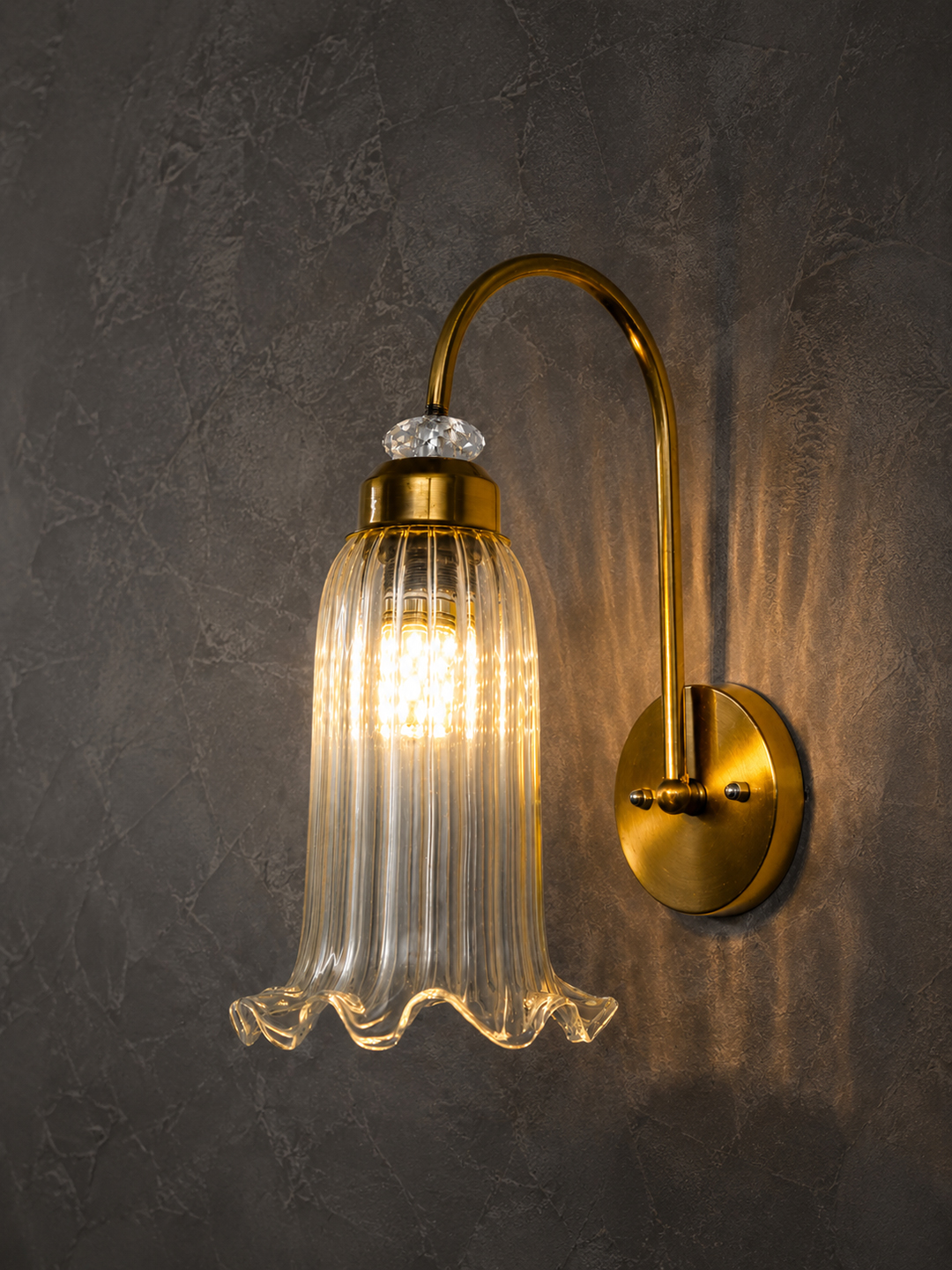 Antique Brass Fluted Glass Wall Sconce Antique brass fluted glass wall light with curved arm and decorative textured glass shade
