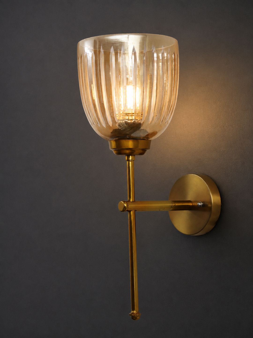 Antique Brass Fluted Glass Wall Sconce Antique brass wall light with amber ribbed glass shade and curved arm, shown with product dimensions.