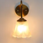 Flower Glass Wall Lamp with antique brass finish and decorative clear floral glass shade.