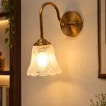 Flower Glass Wall Lamp with antique brass finish and decorative clear floral glass shade.